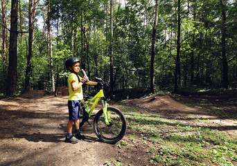 Young boy riding in the wild forest.
