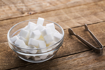 Closeup of sugar cubes in glass bowl with clip on table
