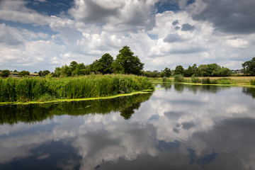 Obraz premium the river stour at fiddleford mill with clouds and reflections in river