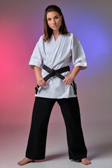 Athletic woman in traditional kimono is practicing karate in studio. © nazarovsergey