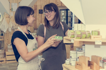 Female shopkeeper helping a customer in zero waste store.