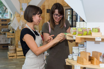 Female shopkeeper helping a customer in zero waste store.