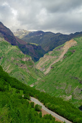 Beautiful mountain landscape. Green grass. Clouds in the sky. Travel concept.