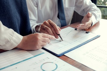 Businessman analyzing investment charts and pressing calculator buttons over documents. Accounting Concept.