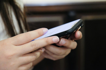 Women's hands holding cell telephone watching social media in a smart phone. social network concept with smart phone