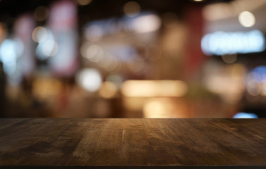 Empty dark wooden table in front of abstract blurred bokeh background of restaurant . can be used for display or montage your products.Mock up for space.