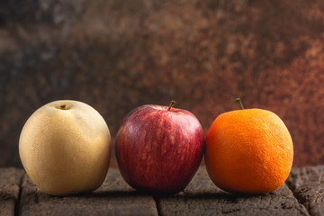 Apple, Orange and Asian Pear on Wooden Table.
