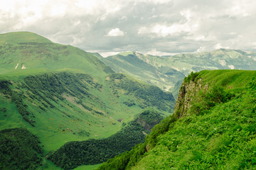 Obraz premium Beautiful mountain landscape. Green grass. Clouds in the sky. Travel concept.
