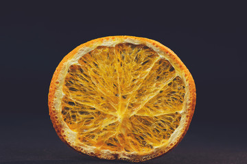 Dry slices of citrus fruit on a black background. Space for text.