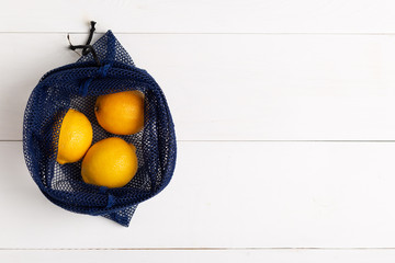A reusable shopping bag with lemons on white background