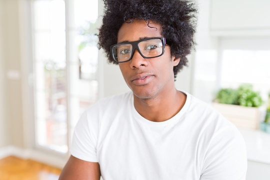 African American man wearing glasses Relaxed with serious expression on face. Simple and natural with crossed arms