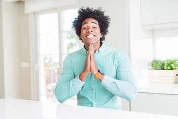 Fototapeta na wymiar African American business man wearing elegant shirt praying with hands together asking for forgiveness smiling confident.