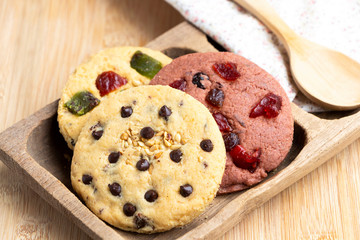 Mixed fruits cookie and Chocolate chip with wooden tray on the wood table. Delicious homemade baked cookie.