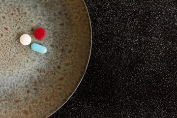Colored pills or medications on a plate. Health concept. Copy space Legal drugs of the pharmaceutical industry.