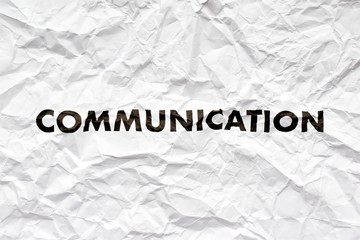 Crumpled white paper with the word communication printed in black. Concept of bad disrupted communication or miscommunication. Symmetrical shot with copy space.