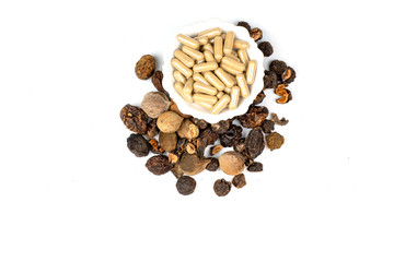 triphala ayurvedic  plant have  chebulic myrobalan fruit,  amla fruit, and  belleric myrobalan fruit on white background ,  transparent clear capsules containg triphala powders