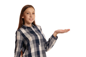 Beautiful teenage girl in a casual checkered shirt is posing isolated on white studio background.