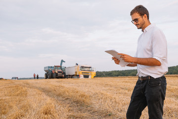Happy farmer standing in a wheat field after the harvest. Agriculture concept