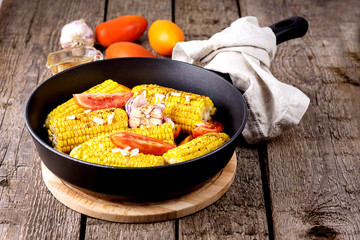 Fried Corn and Tomatoes in a Pan with Oil and Spices Tasty Grilled Vegetables Corn and Tomatoes Autumn Harvest Diet Food Dinned Wooden Background Copy Space