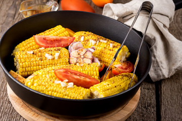 Fried Corn and Tomatoes in a Pan with Oil and Spices Tasty Grilled Vegetables Corn and Tomatoes Autumn Harvest Diet Food Dinned Wooden Background Close Up