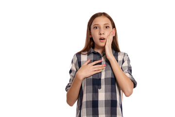 Fototapeta premium Beautiful teenage girl in a casual checkered shirt is posing isolated on white studio background.