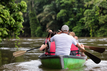 People exploring a wild nature area by rowing boat. Ecotourism concept. Tortuguero national park....