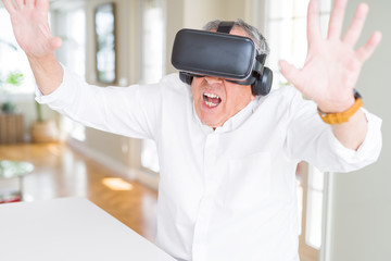 Naklejka na ściany i meble Man wearing virtual reality glasses with scary expression