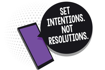 Writing note showing Set Intentions. Not Resolutions.. Business photo showcasing Positive choices for new start achieve goals Cell phone receiving text messages chat information using applications