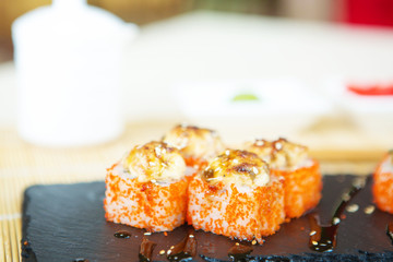 salmon sushi rolls on black slate surface. Japanese food Healthy and tasty food.