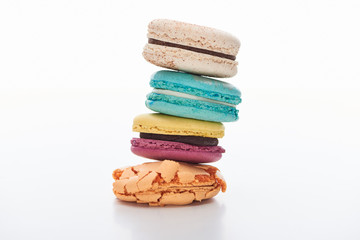 stack of delicious colorful French macaroons of different flavors on white background
