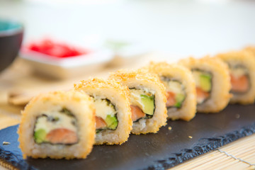 Rolls with shrimp in a black plate on a wooden table. Sushi closeup Healthy and tasty food.