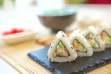 Sushi roll with salmon, smoked eel, avocado, cream cheese on black background. Sushi menu. Japanese food. Healthy and tasty food.