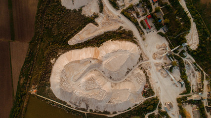 A village next to a quarry and a forest, shot from above.