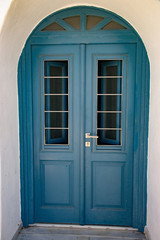Green door in Fira, Santorini island, Greece. Characteristic entrance in vintage colored wood.