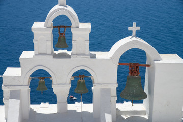 Bell tower of Oia in Santorini Greek island.Classic bell tower with bells. View of the caldera gulf.