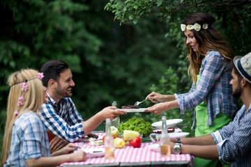 Group of friends making barbecue in the nature