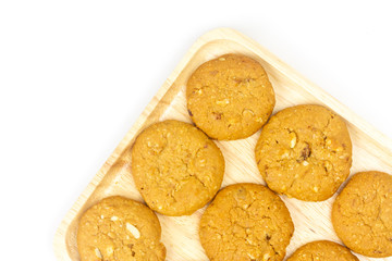 Oatmeal raisin cookies and wooden plate isolated on white background, top view.