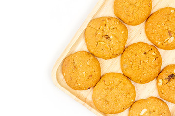 Oatmeal raisin cookies and wooden plate isolated on white background, top view.