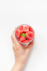 Woman hands with crushed watermelon in glass