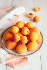 Delicious ripe apricots on a white plate.