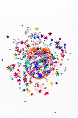 Festive star confetti with red alarm clock concept
