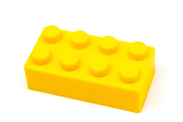 Yellow plastic building block isolated on white background. Developmental toys for children.
