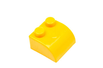 Yellow plastic building block isolated on white background. Developmental toys for children.