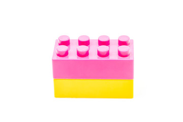 Pink and yellow plastic building block isolated on white background. Developmental toys for children.