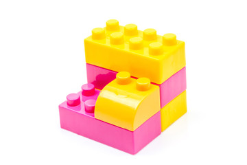 Pink and yellow plastic building block isolated on white background. Developmental toys for children.