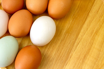 White and brown eggs on wooden background.