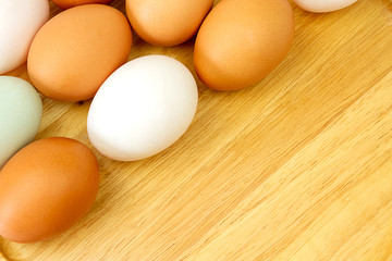 White and brown eggs on wooden background.