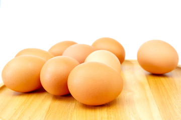 Fresh brown eggs on wooden isolate white background.