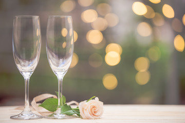 Rose flower with glass wine on wooden table blur bokeh background