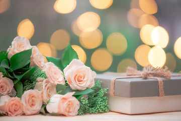 Rose flower, gift box, on wooden table with bokeh background